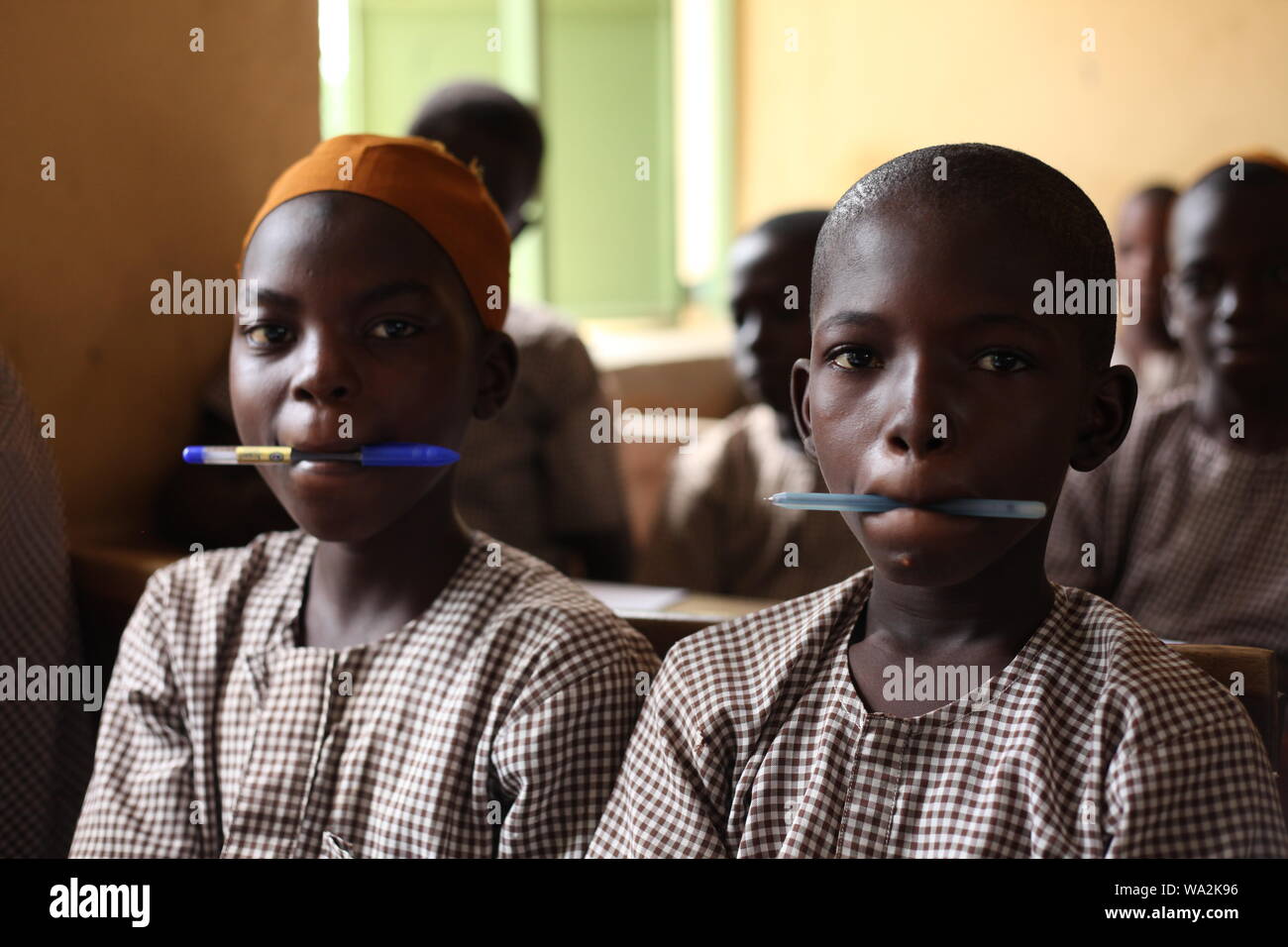 Gli studenti che frequentano la classe in Nigeria la scuola primaria in camera inadeguata Foto Stock