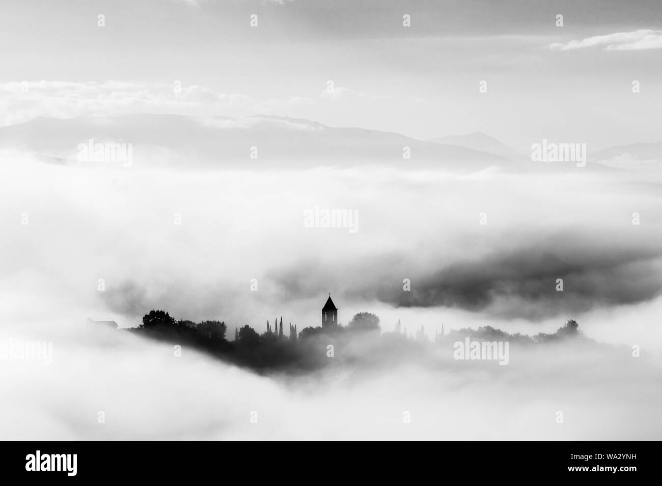 Vista surreale di Mora town (Assisi) quasi completamente nascosto dalla nebbia Foto Stock