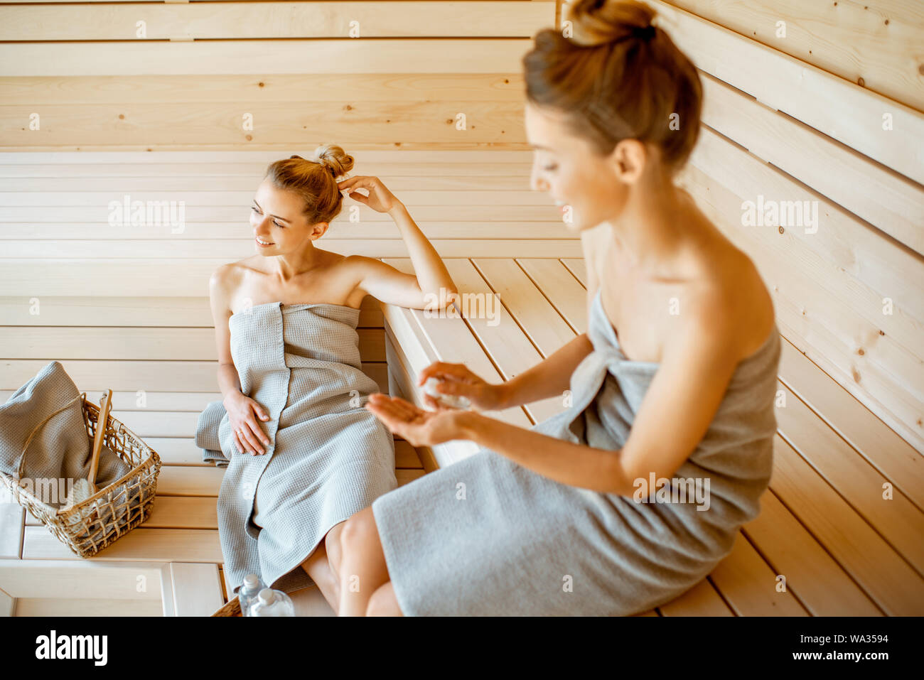 Due giovani amiche di rilassarvi nella sauna, seduti insieme e di prendersi cura di se stessi. Concetto di amicizia femminile e il trattamento termale Foto Stock