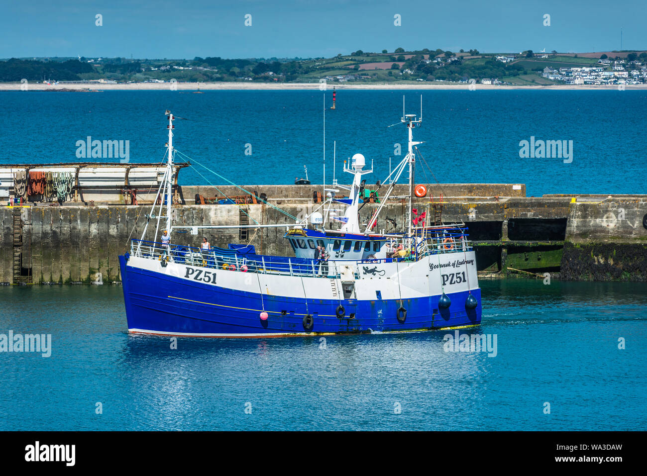 Un peschereccio di ritornare con le proprie catture al Porto di Newlyn villaggio di pescatori vicino a Penzance in Cornovaglia, Inghilterra, Regno Unito. Foto Stock