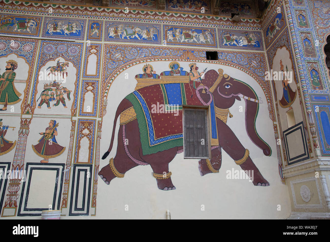 Links neben Hauptmotiv dem des Elefanten kann man die Malerei eines Elefanten und eines Pferdes sehen, welche aus Körpern von Menschen geformt werden Foto Stock
