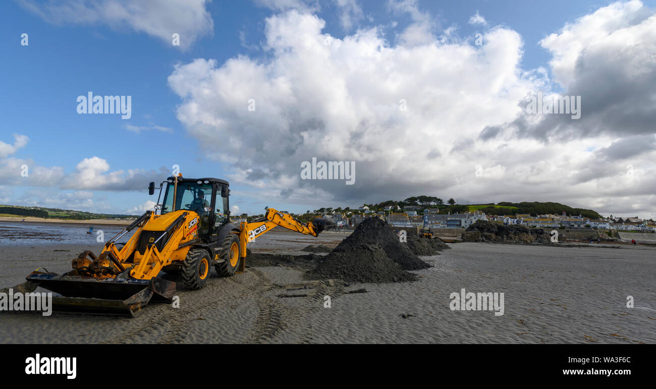 JCB escavatrice, scavando un canale nella sabbia per il turista traghetti, St Michael's Mount, Marazion, vicino a Penzance, Cornwall, Regno Unito Foto Stock