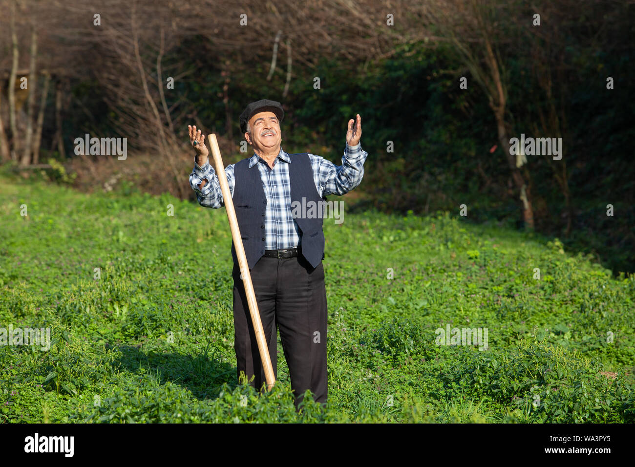 Vecchio contadino lavorando in fattoria braccia aperte Foto Stock