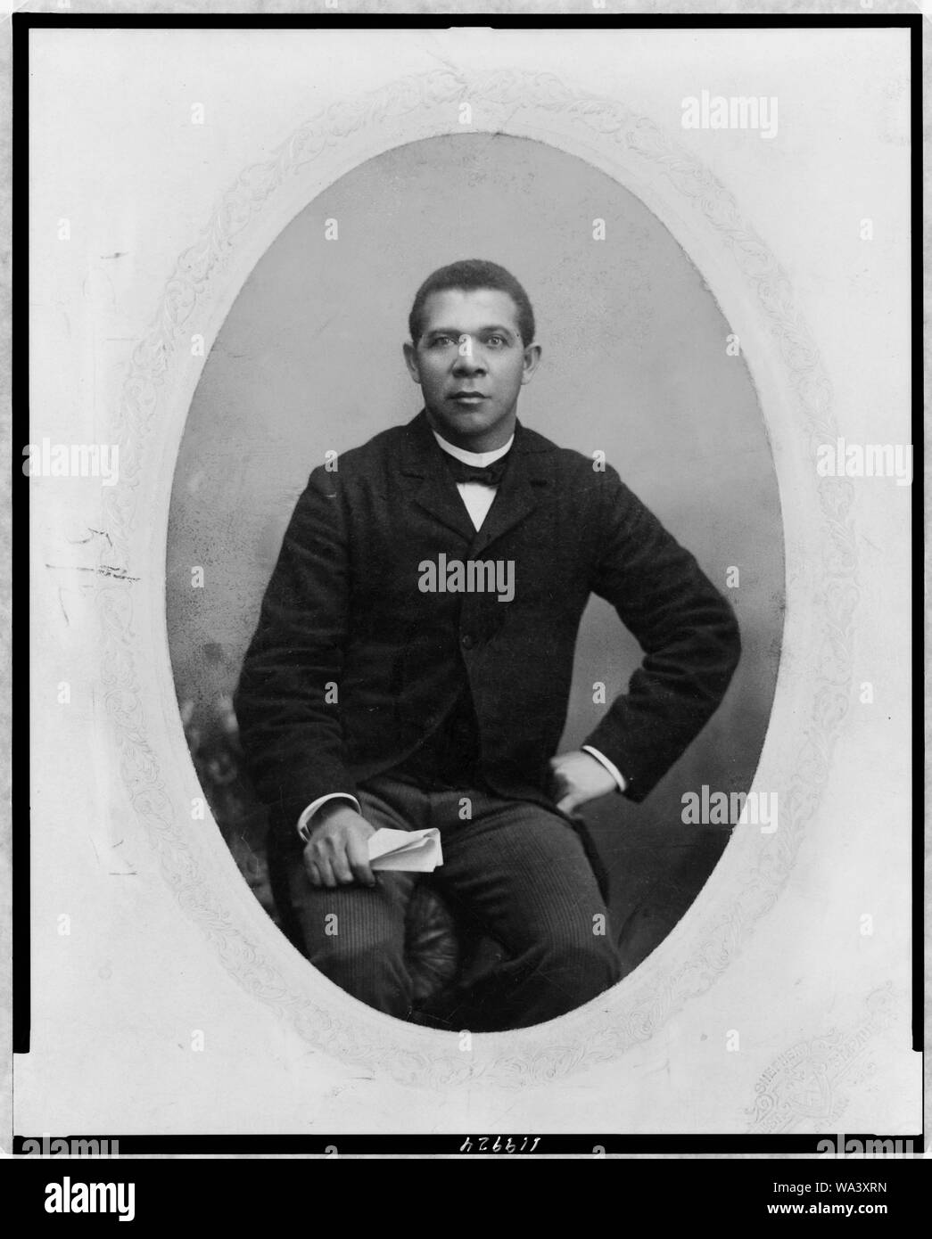 Booker T. Washington, tre quarti di lunghezza verticale, seduto, rivolto verso la parte anteriore Foto Stock