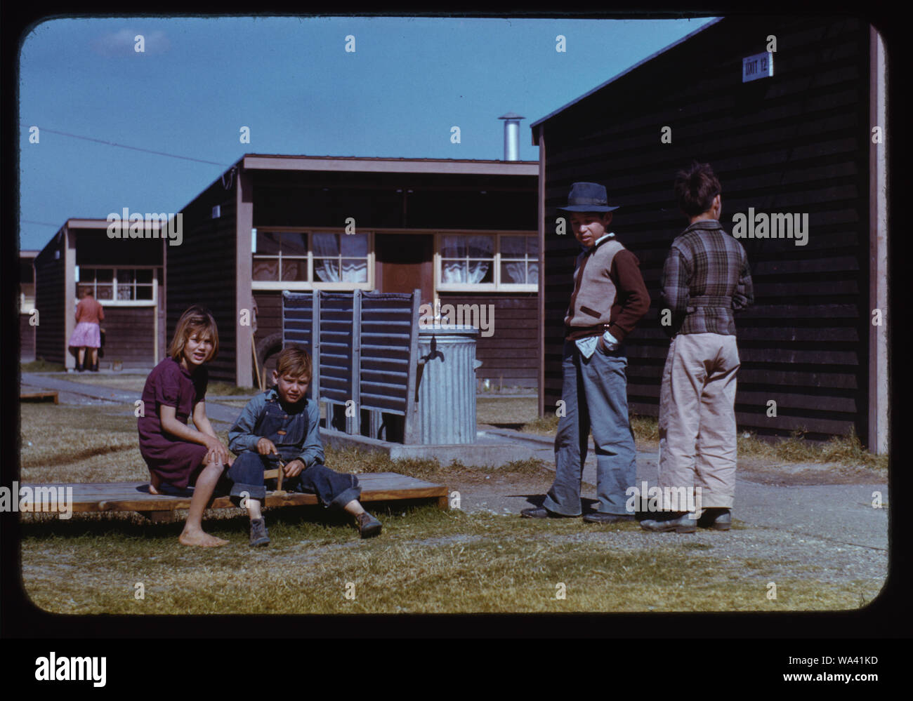 Ragazzo la costruzione di un modello di aeroplano mentre altri bambini a guardare, FSA labour camp, Robstown, Tex. Foto Stock