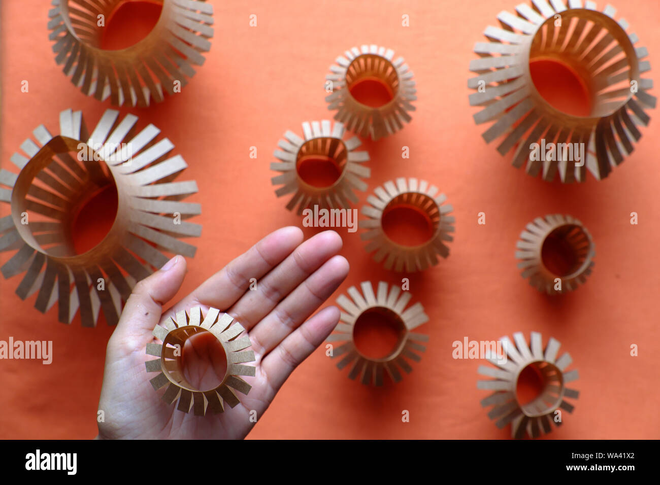 Close up donna tenere in mano una piccola lanterna in palm e gruppo di lanterne di carta su sfondo arancione , ornamentali popolari per metà stagione autunnale Foto Stock