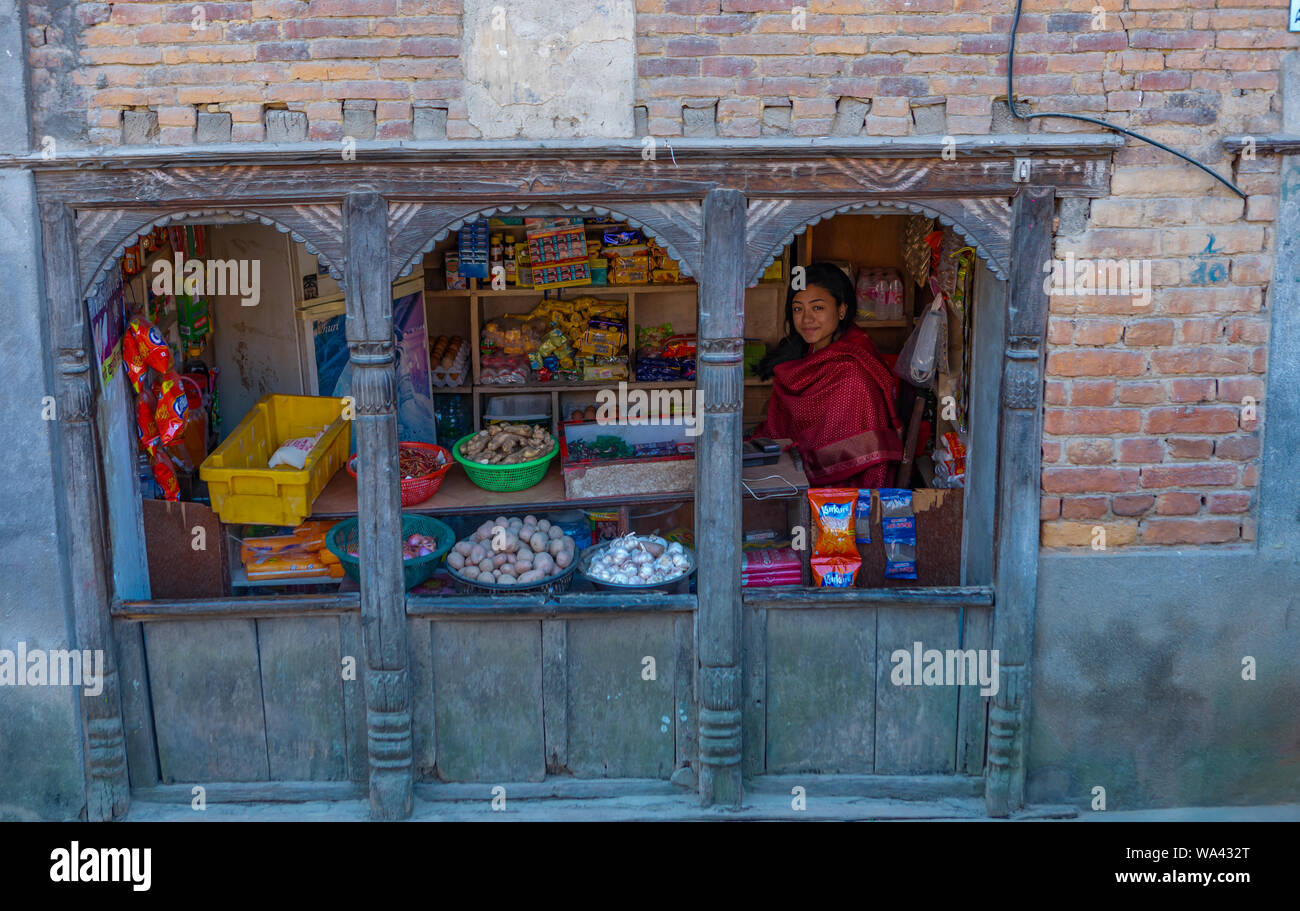 Giovani donne nepalesi di vendita di alimenti e casa ware al di fuori del piccolo negozio di alimentari Foto Stock