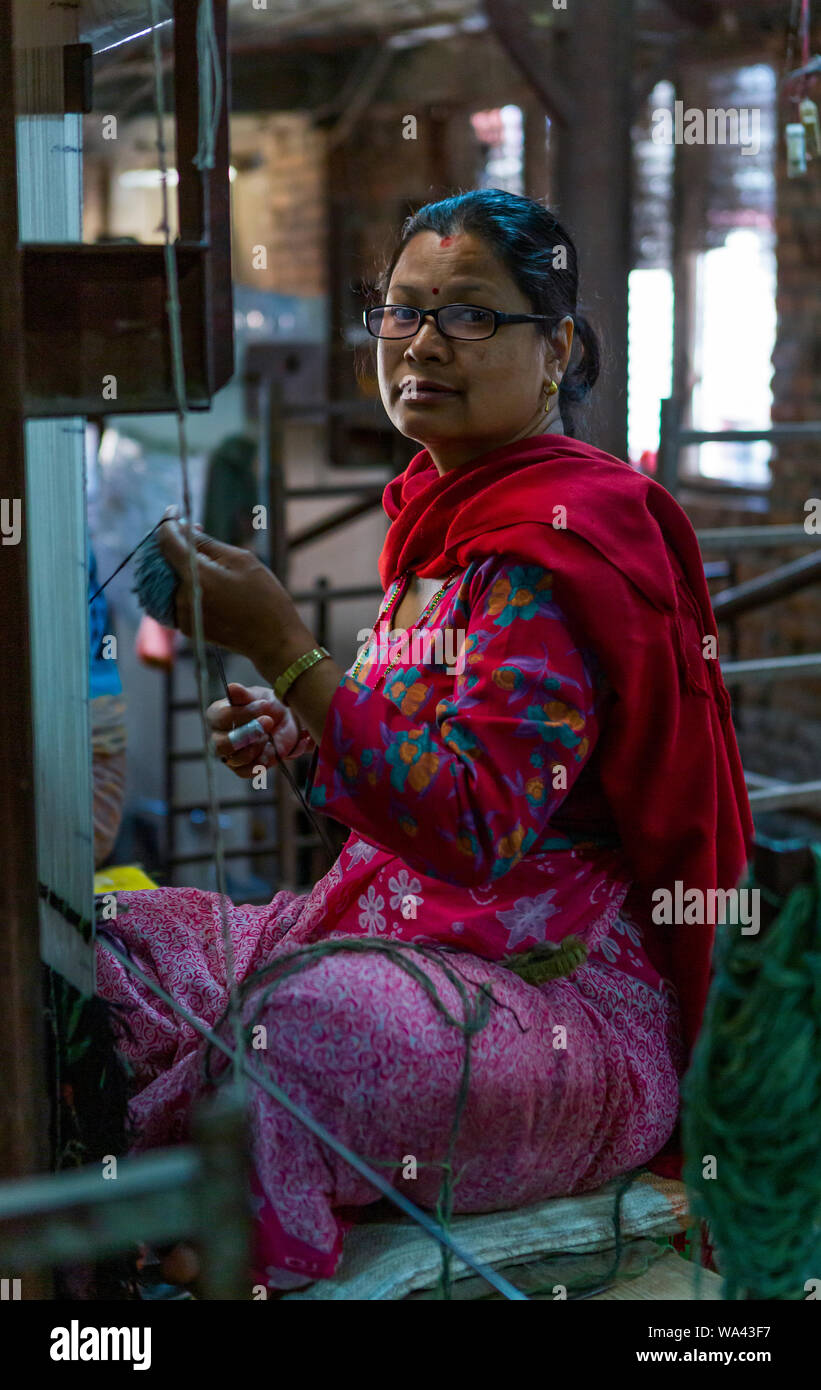 Sorridente donne asiatiche sono tessuti di tessitura su un telaio tradizionale Foto Stock