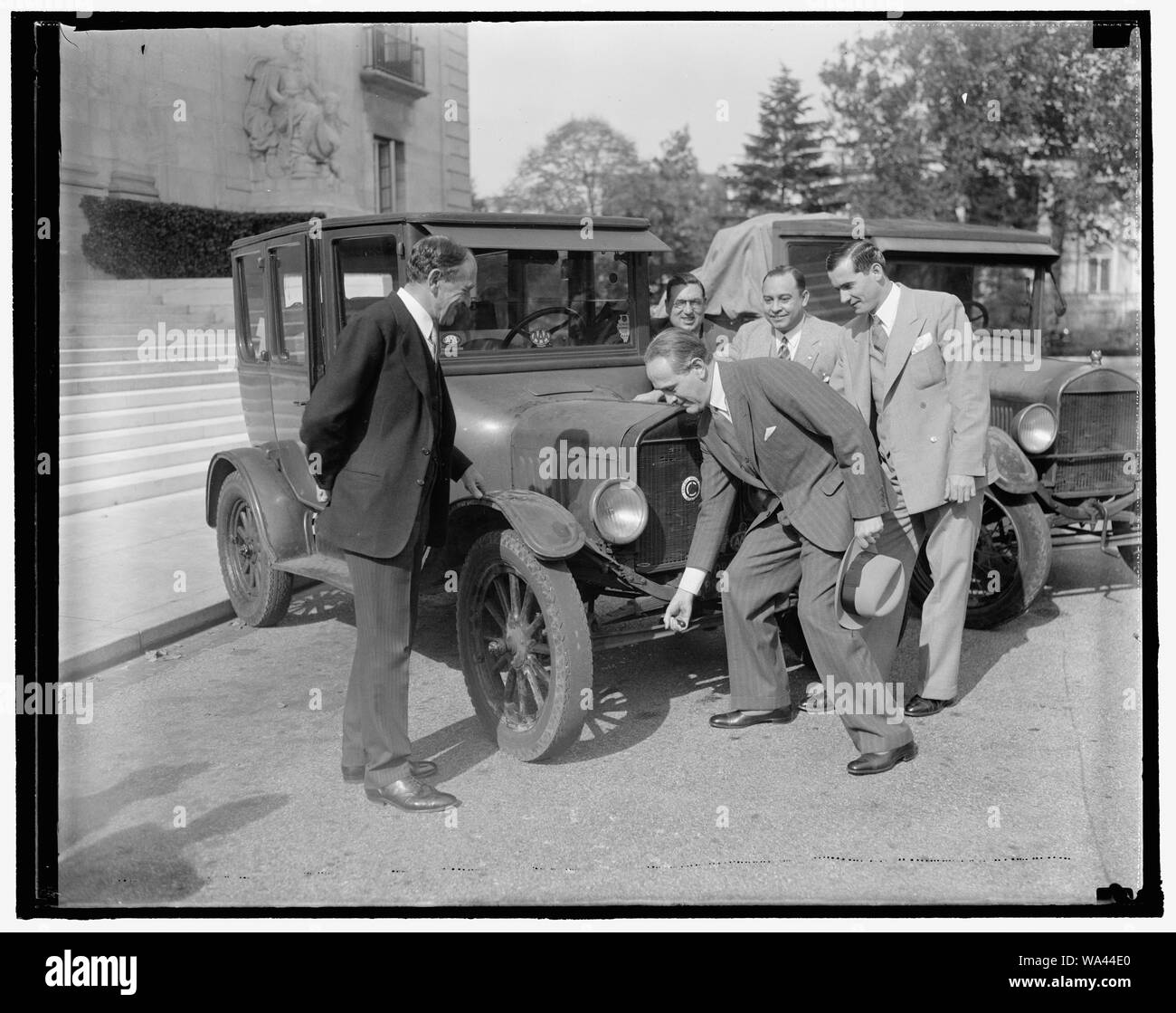 Ambasciatore brasiliano tenta la mano all'avviamento Lizzie. Washington D.C., Ott. 29. Dopo aver ascoltato le esperienze e i disagi dei tre ingegneri brasiliano, che finalmente arrivata nella capitale oggi dopo un periodo di nove anni di cammino del motore da Rio de Janeiro, Ambasciatore brasiliano Oswaldo Aranha ha provato la sua mano a quella di messa in moto della flivvers originale che è sopravvissuto il faticoso viaggio. Viaggiare 15.000 miglia attraverso 14 paesi, la spedizione è stata fatta nell'interesse di un'autostrada internazionale tra il nord e il Sud America. Nella foto, da sinistra a destra: il dottor Leo S. ROWE, Direttore Generale della coppa Foto Stock