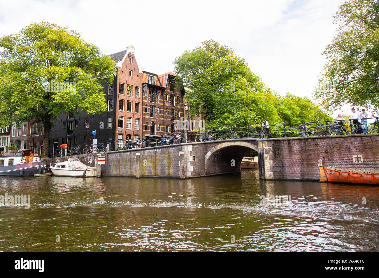 AMSTERDAM, Paesi Bassi - 31 agosto 2018: scene di strada da Amsterdam in un giorno di estate con persone reali, in barca sul canale e architettura. Foto Stock
