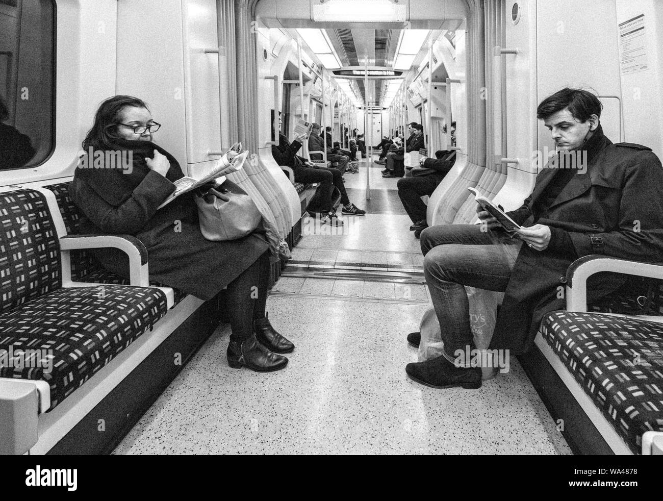 I passeggeri di lettura e ignorando ogni altra seduta in silenzio su un metro di Londra treno della District Line in direzione ovest da Earls Court Foto Stock