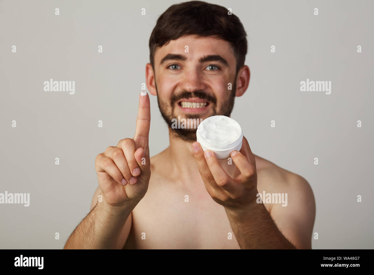 Adolescente utilizza la crema per la pelle. Visualizza la crema in telecamera Foto Stock
