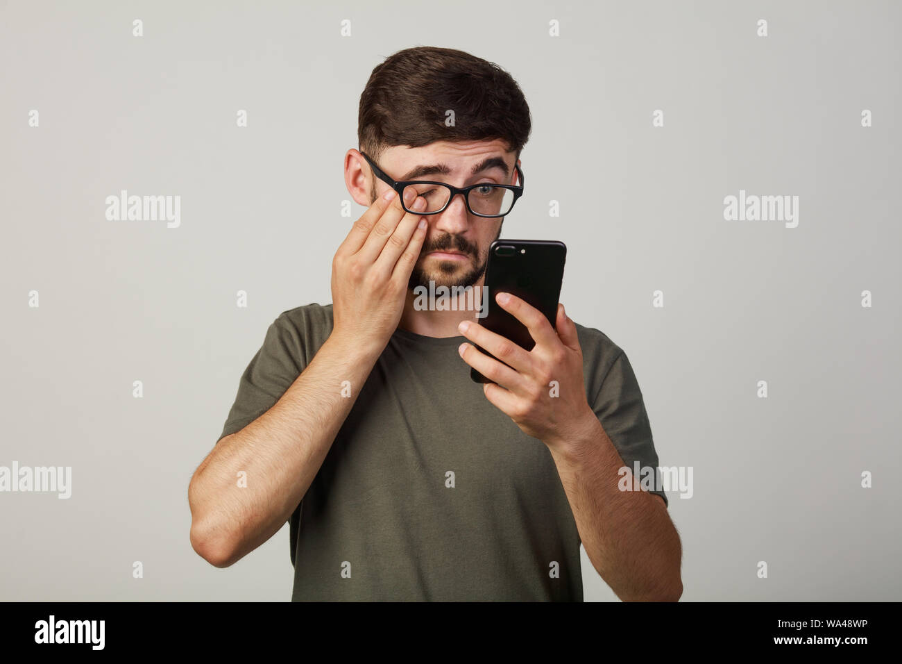 Guy si copre il viso con la sua mano. Ha fatto un errore fatale. Egli non scegliere ciò di cui ha bisogno. vittima di un furto di denaro online da hacker Foto Stock