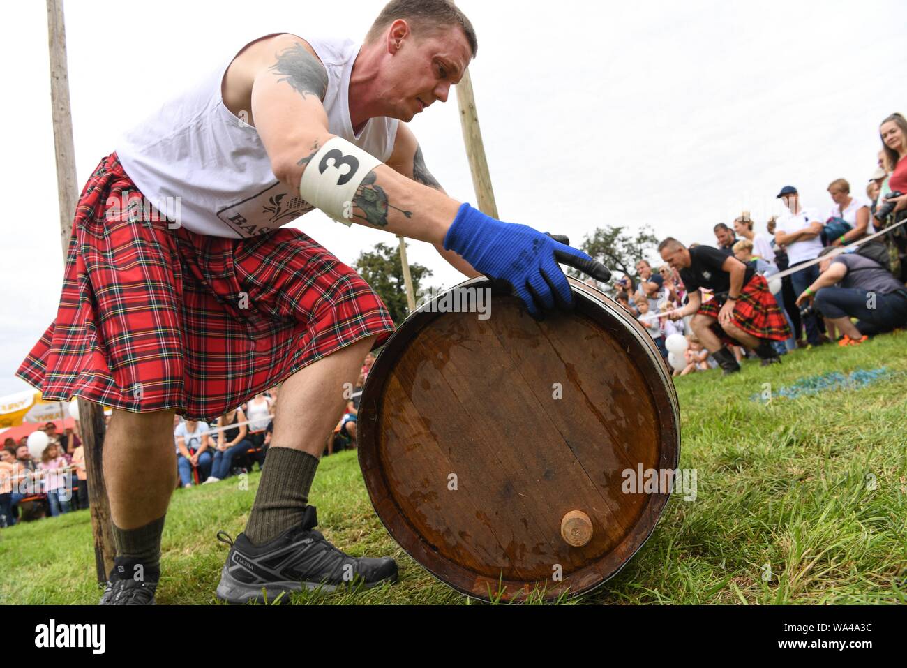 Wilhelmskirch, Germania. 17 Ago, 2019. Un partecipante del 'Oberschwäbischen Highländgames' rotoli una canna attraverso un corso di slalom. Squadre di tutta la Germania meridionale si sono incontrati per mettere alla prova la loro resistenza a giochi. Credito: Felix Kästle/dpa/Alamy Live News Foto Stock