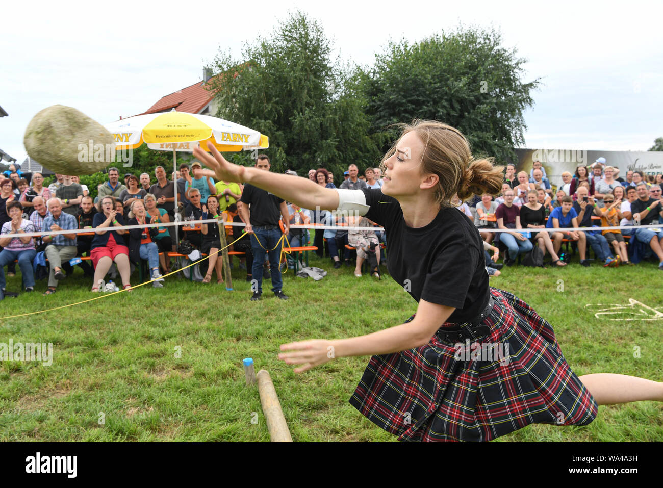 Wilhelmskirch, Germania. 17 Ago, 2019. Un partecipante del 'Oberschwäbischen Highländgames' getta una pietra intorno alla distanza migliore. Squadre di tutta la Germania meridionale si sono incontrati per mettere alla prova la loro resistenza a giochi. Credito: Felix Kästle/dpa/Alamy Live News Foto Stock