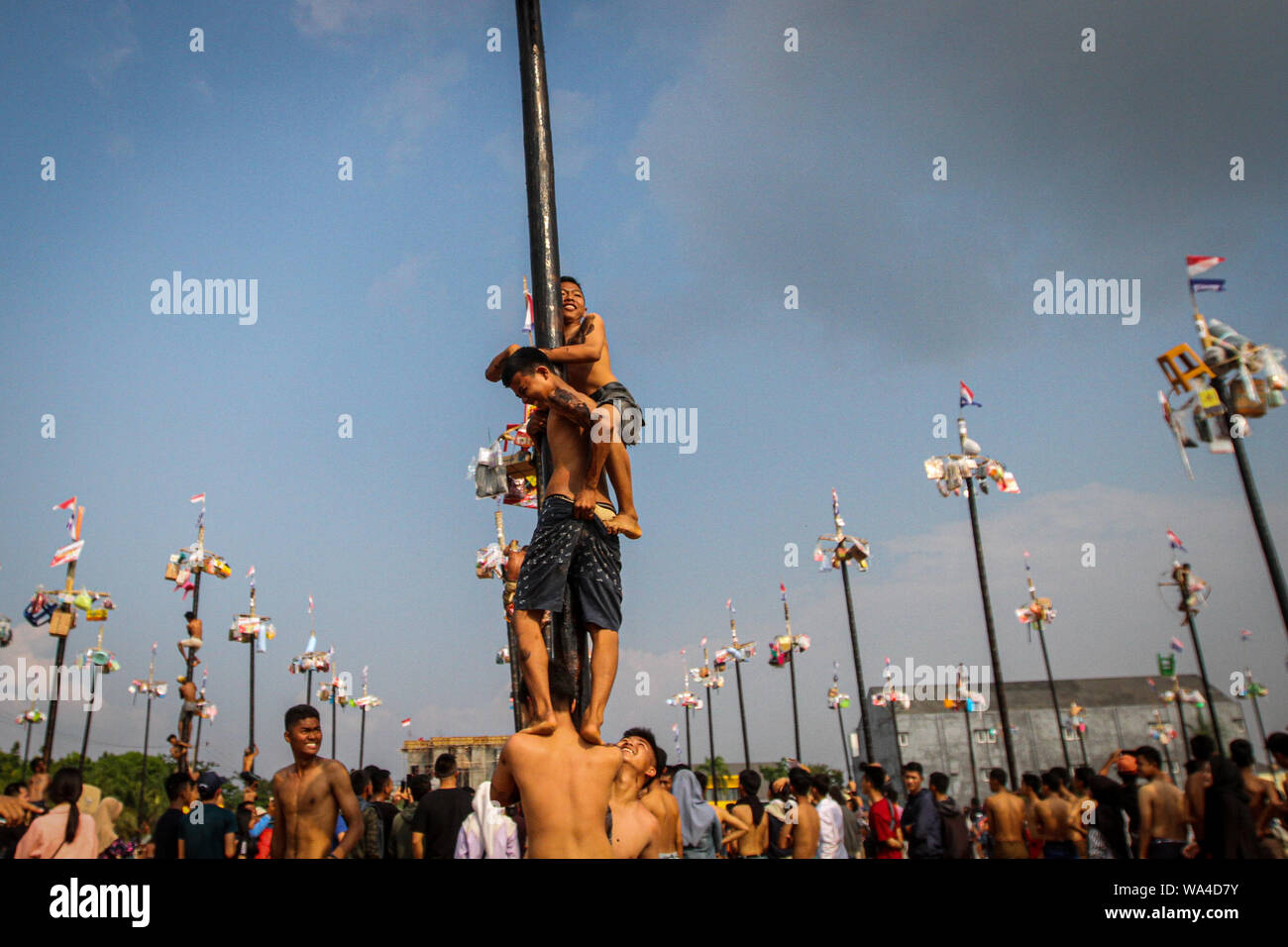 I partecipanti che lottano per salire poli grassa durante panjat pinang, un polo concorso di arrampicata per celebrare l'Indipendenza Indonesiana giorno del 74º anniversario. Foto Stock