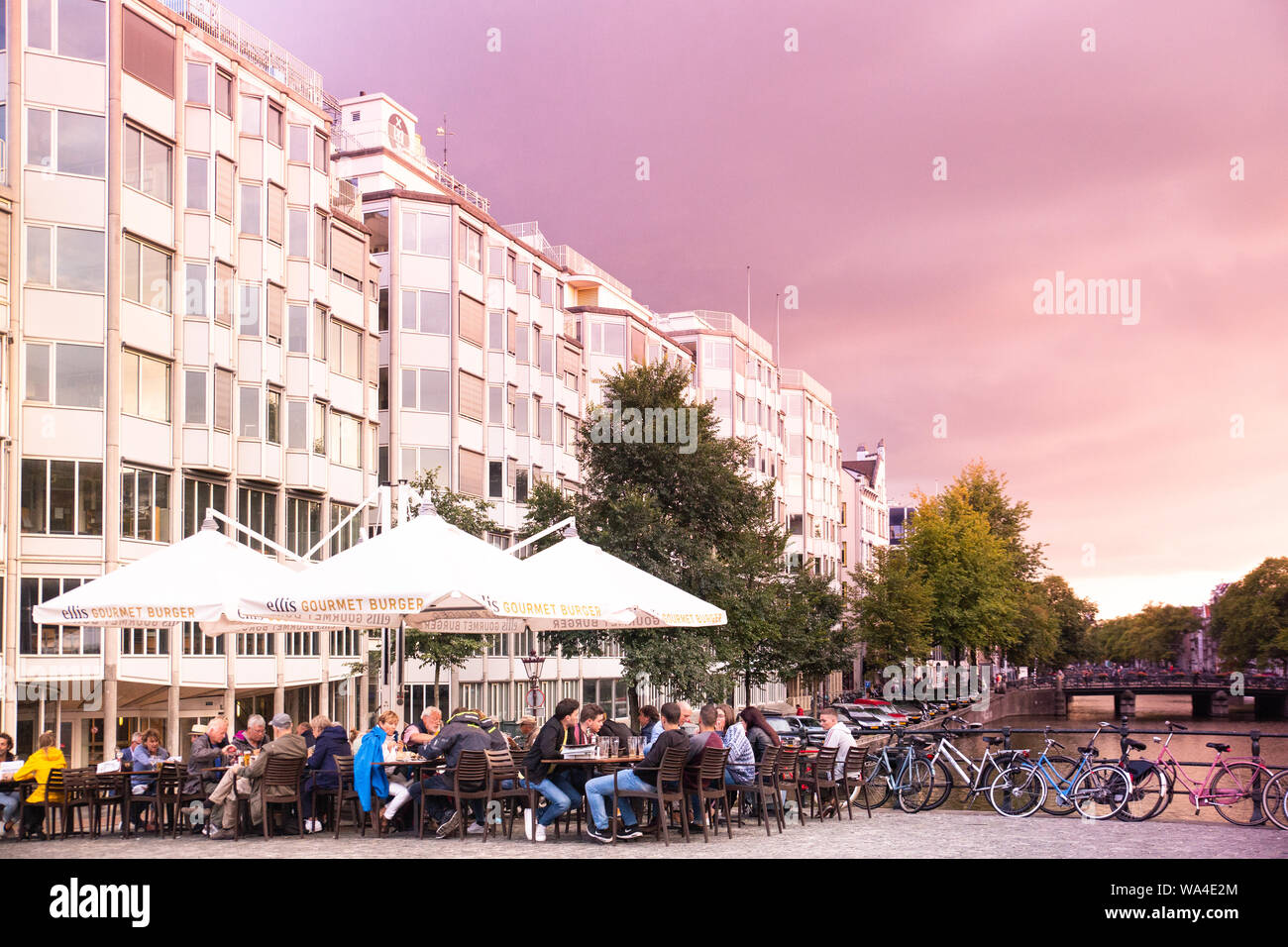 AMSTERDAM, Paesi Bassi - 31 agosto 2018: scene di strada da Amsterdam con persone cenare all'aperto al tramonto. Foto Stock