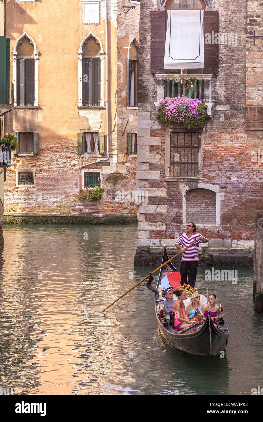 Venezia, Italia - 20 Luglio 2012 - di un gondoliere e la sua gondola con i turisti sul canale di Venezia. Venezia è famosa per le sue gondole e canali che sono Foto Stock