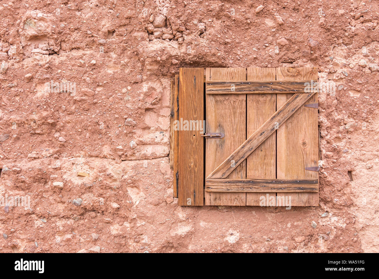 Vecchia chiusa la finestra in legno su un muro di pietra con spazio di copia Foto Stock