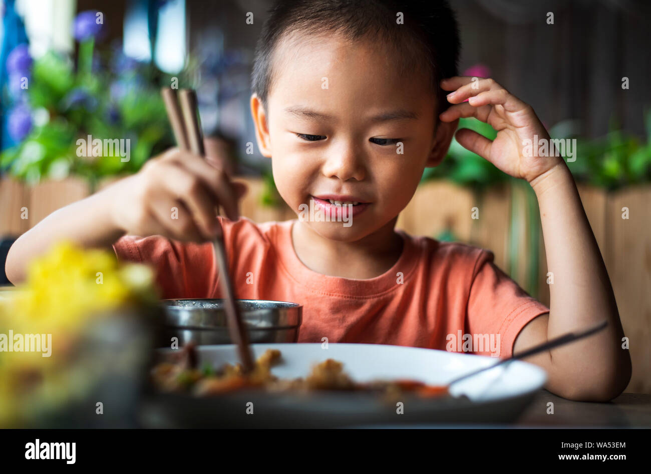 Carino ragazzo asiatico con pranzo presso il ristorante Foto Stock