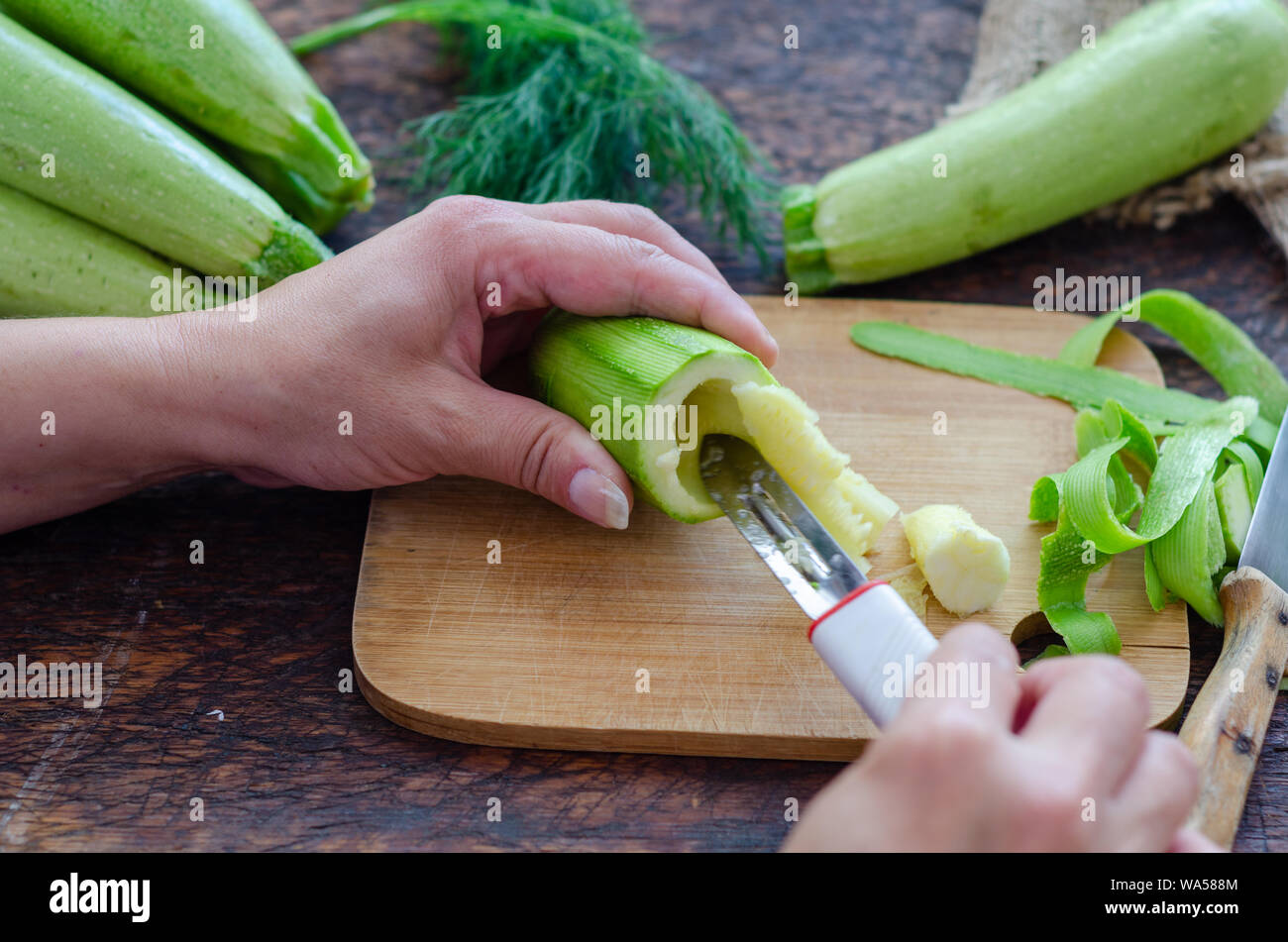 La donna è il carving le zucchine in cucina. Foto Stock