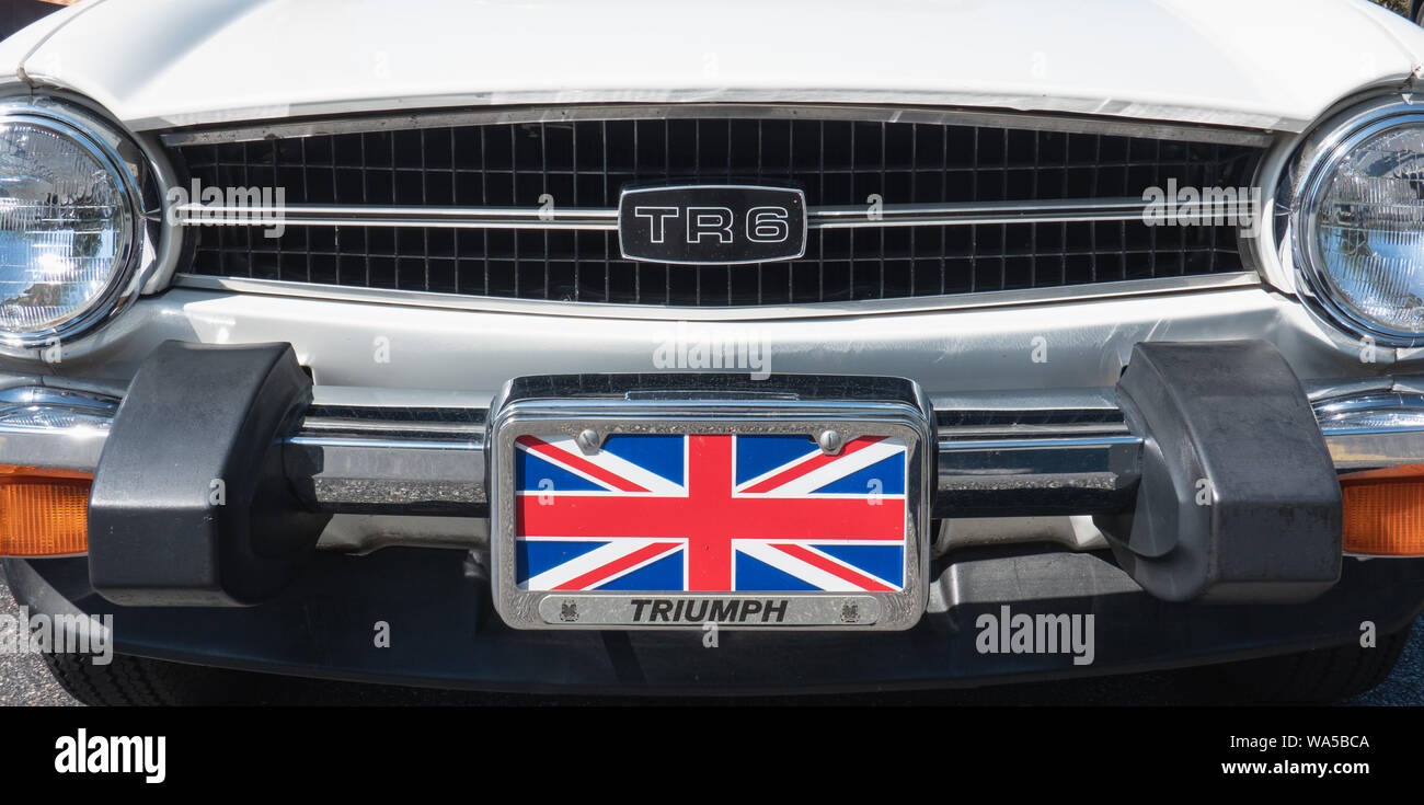 West Chester, PA - Agosto 11, 2019: in prossimità della estremità anteriore della griglia e di un bianco Triumph TR6 con la bandiera britannica in un supporto per la targa. Foto Stock