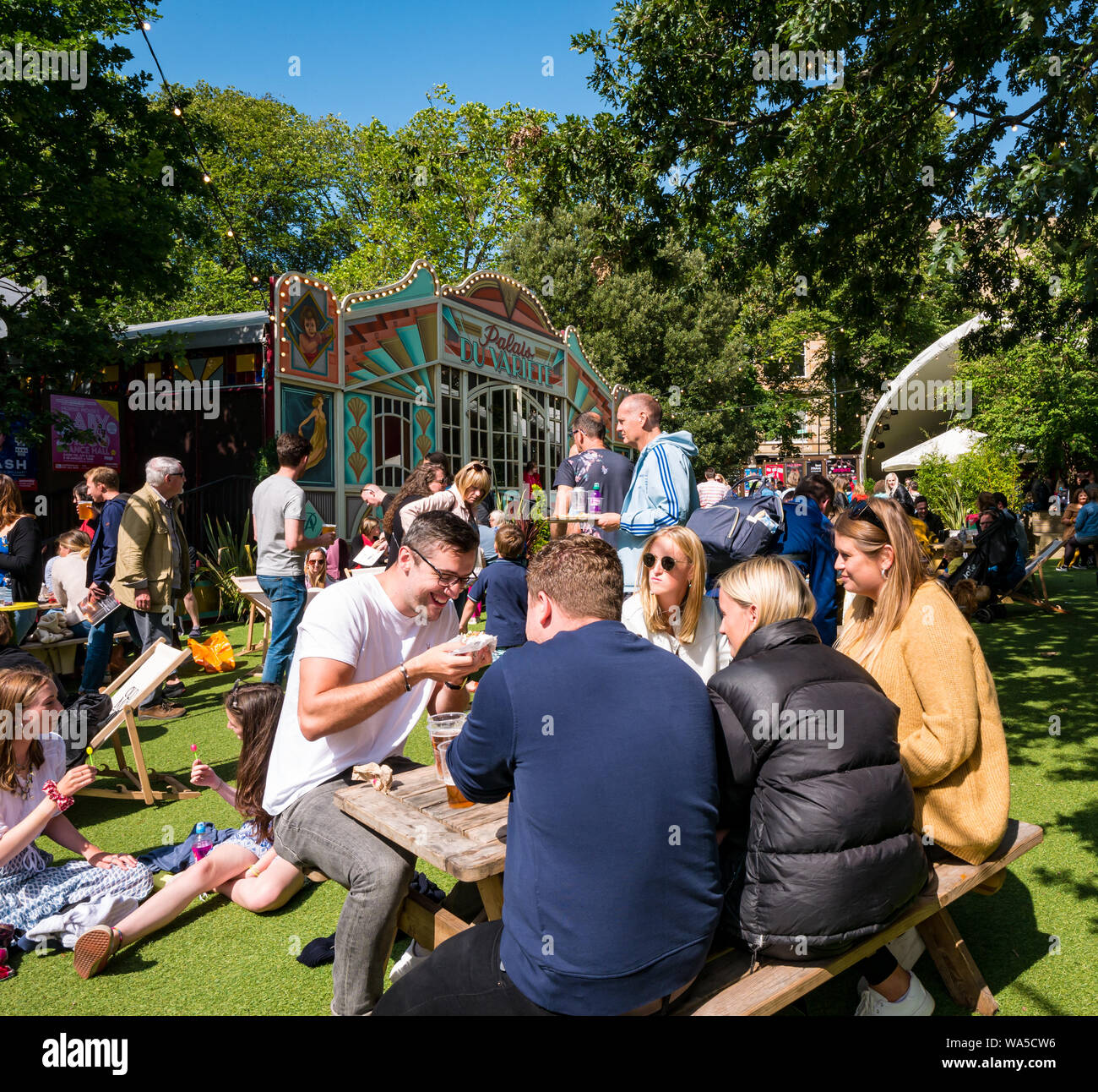 Persone rilassante a George Square Gardens su occupato giorno soleggiato durante il Festival di Edimburgo Fringe, Scotland, Regno Unito Foto Stock
