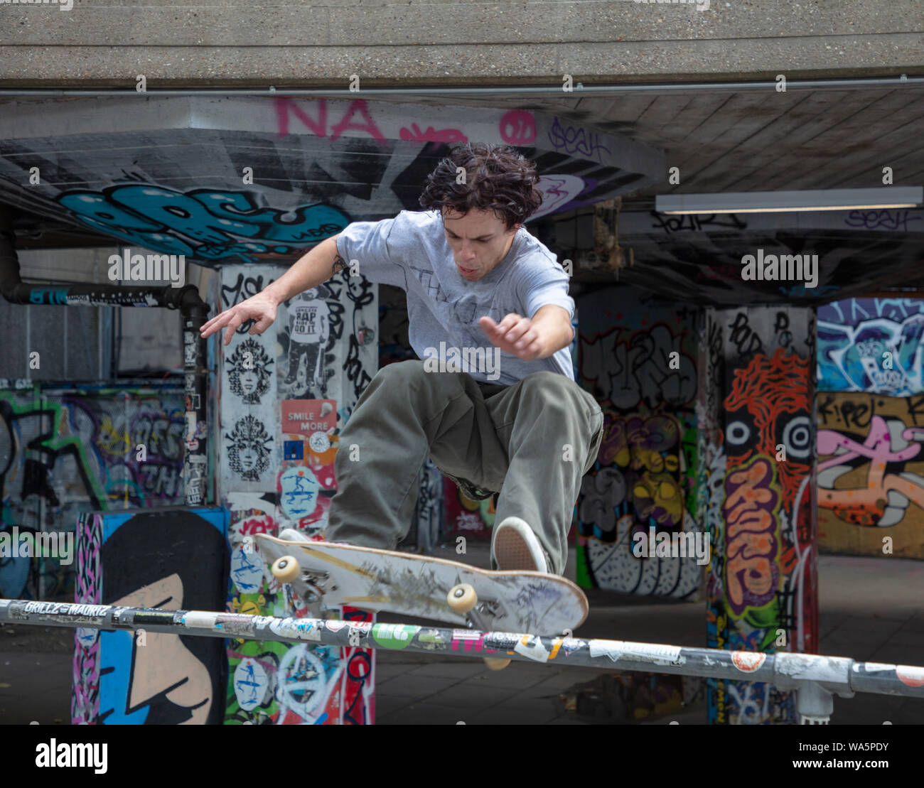 Guidatore di skateboard che mostra la sua abilità su una pista da skateboard sulla South Bank di Londra in un giorno di agosto. Foto Stock