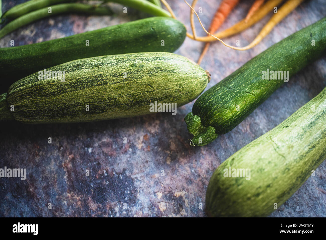 Materie le zucchine e le carote su un rustico sfondo concreto Foto Stock