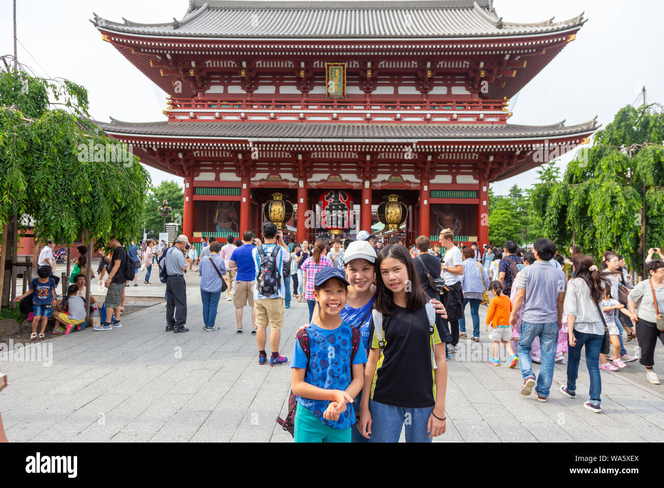 Asakusa, Giappone - 13 Giugno 2015 - Una famiglia asiatica sorge di fronte al famoso Tempio di Asakusa la big red lanterna per le loro foto di famiglia su Giugno 13, 2015 Foto Stock