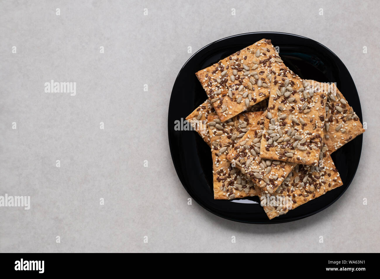 I cookie di cereali su una piastra nera con copia spazio. Dolci fatti in casa. Il cibo gourmet. Cibo sano, vista dall'alto. Design laconico. Foto Stock