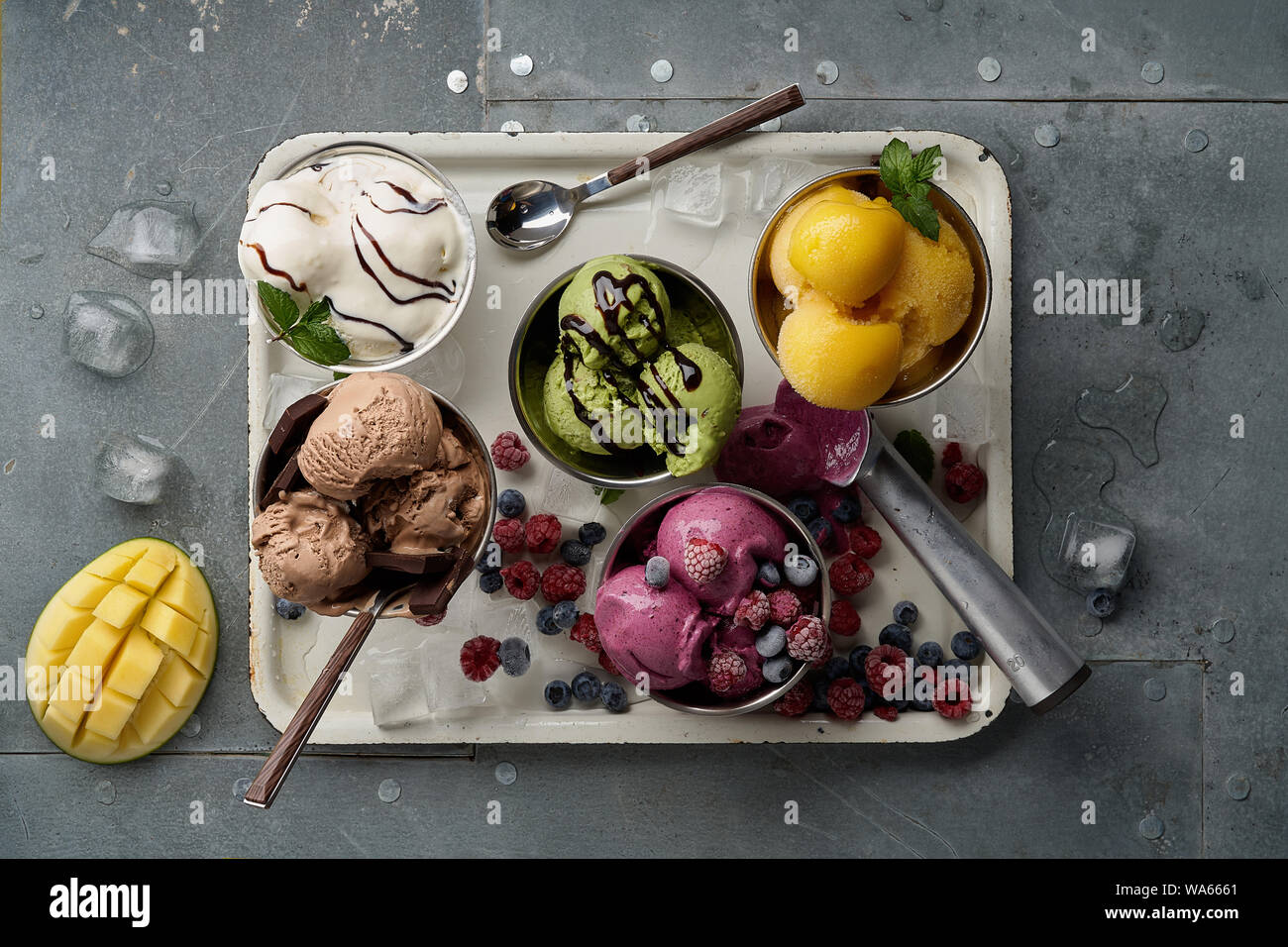 Un assortimento di sapori e colori di gourmet gelato italiano servito sul tavolo in acciaio. Mango, cioccolato, Verde matcha ice cream Foto Stock