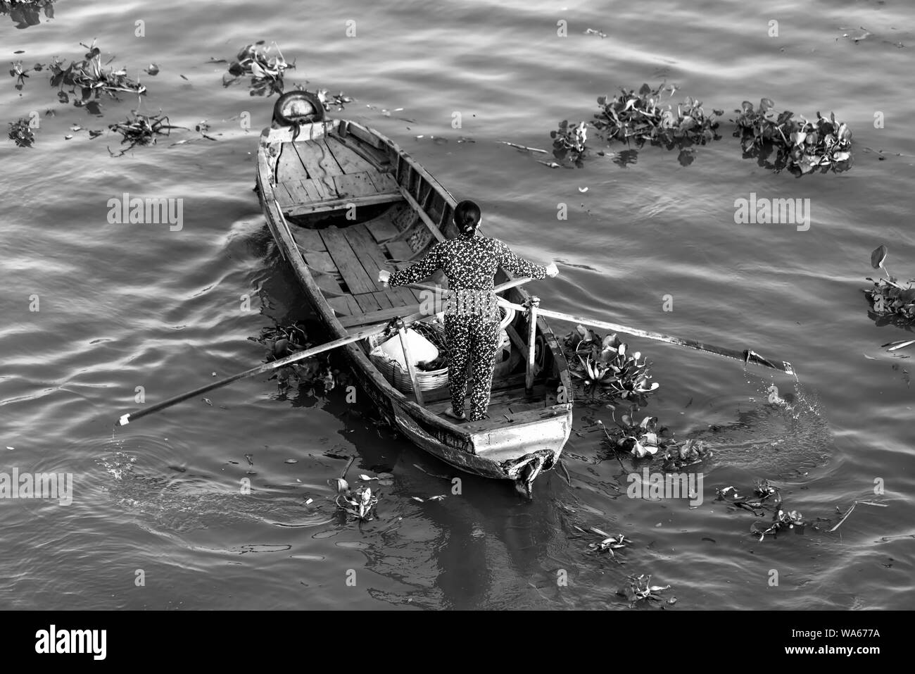 Traghetto di canottaggio donna porta i visitatori o i prodotti agricoli sul fiume mercato galleggiante , questo è il trasporto principale il nuovo anno lunare in Soc Trang, Foto Stock