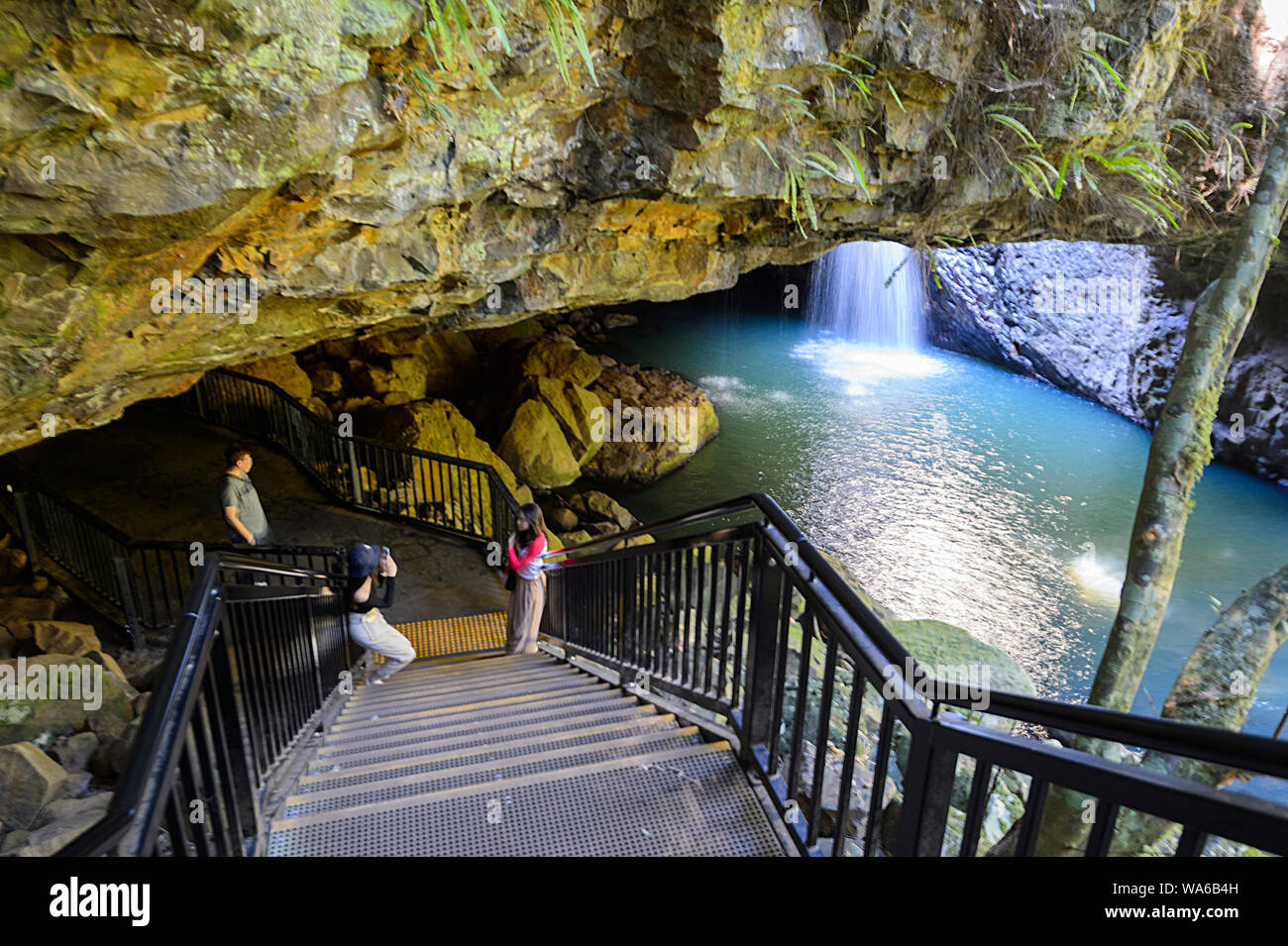 Tourist in posa davanti il celeberrimo Ponte naturale di Springbrook National Park, entroterra della Gold Coast, Queensland, QLD, Australia Foto Stock