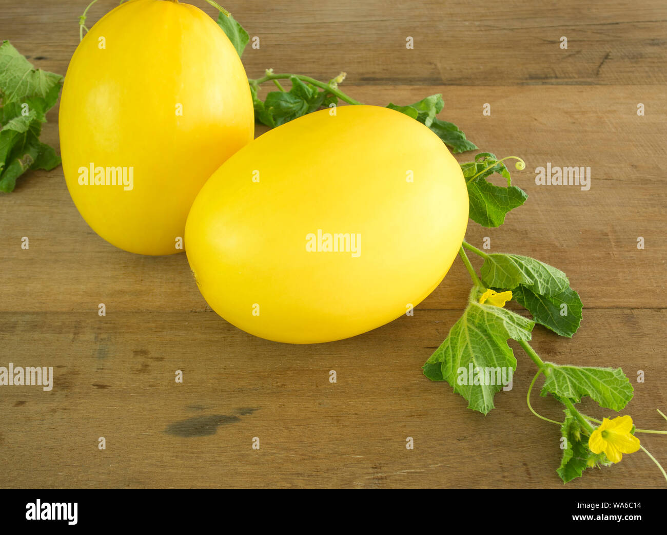 Freschi di melone giallo ( Canarie o melone melone invernale) posto su una tavola di legno. Foto Stock