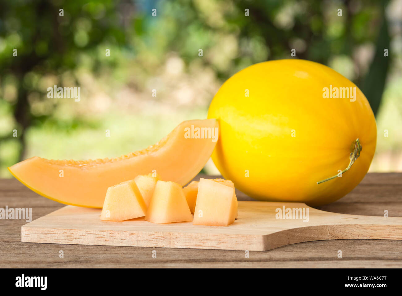 Fresche a fette giallo melone ( Canarie o melone melone invernale) pezzi in legno; la piastra di messa a fuoco selezionata. Foto Stock