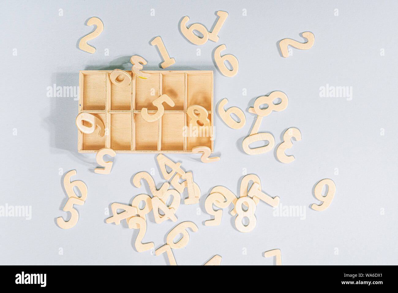Alcuni numeri di legno per essere ordinati in una piccola scatola di legno Foto Stock