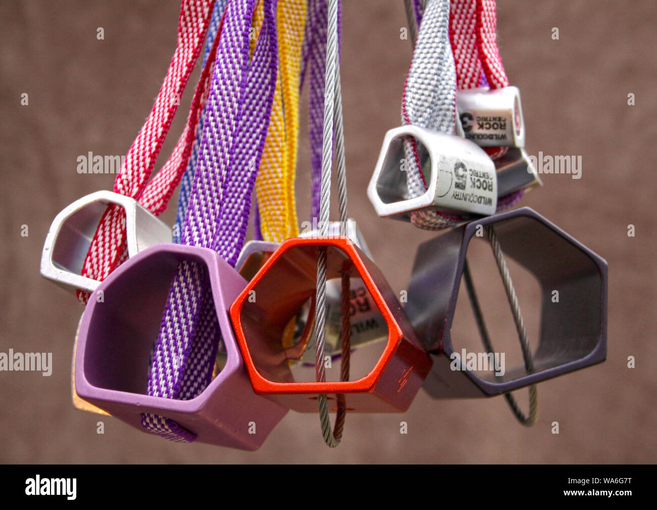 esici di arrampicata colorati appesi su una cinghia Foto Stock
