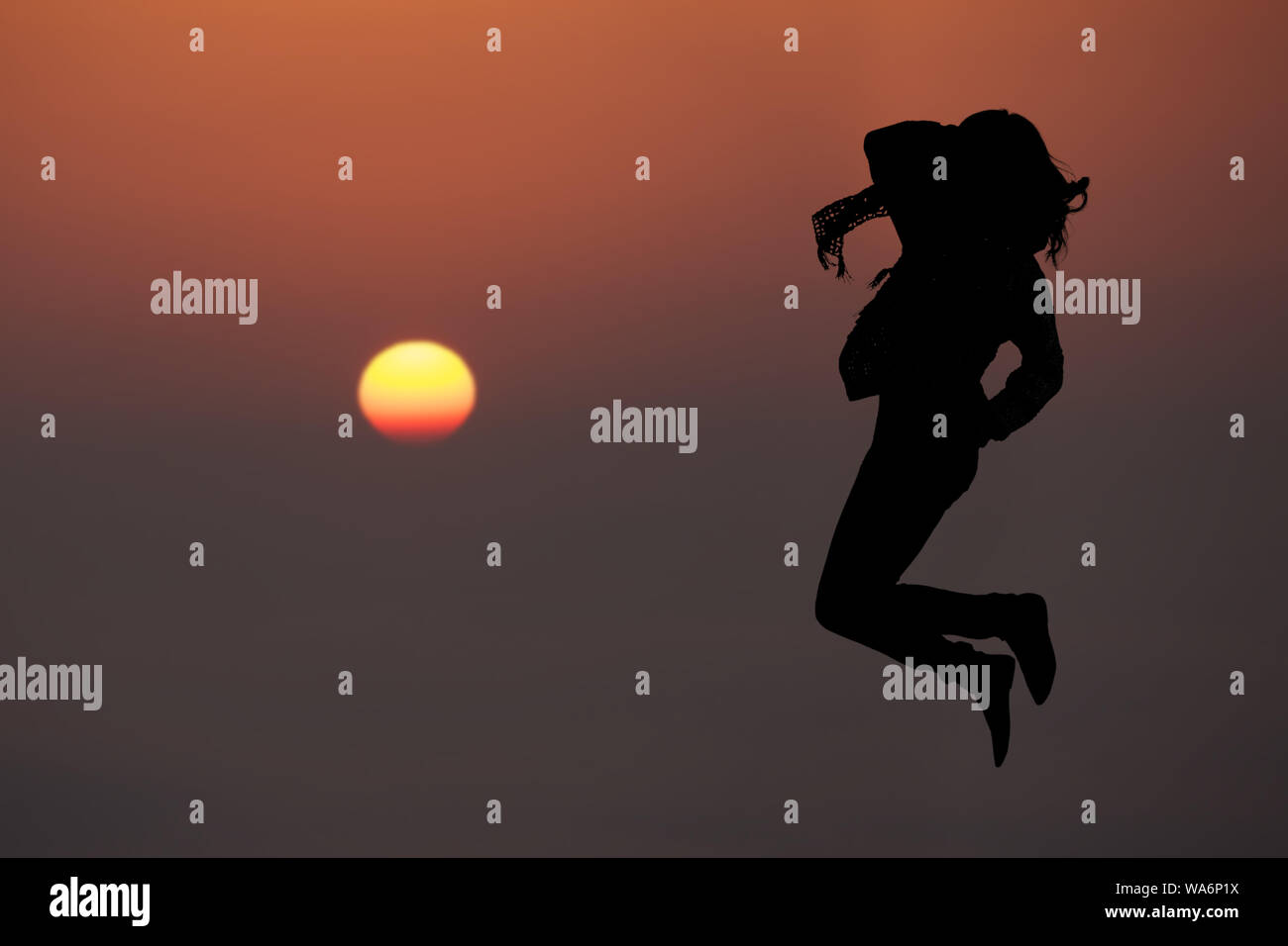 Silhouette di una donna che salta in aria Foto Stock