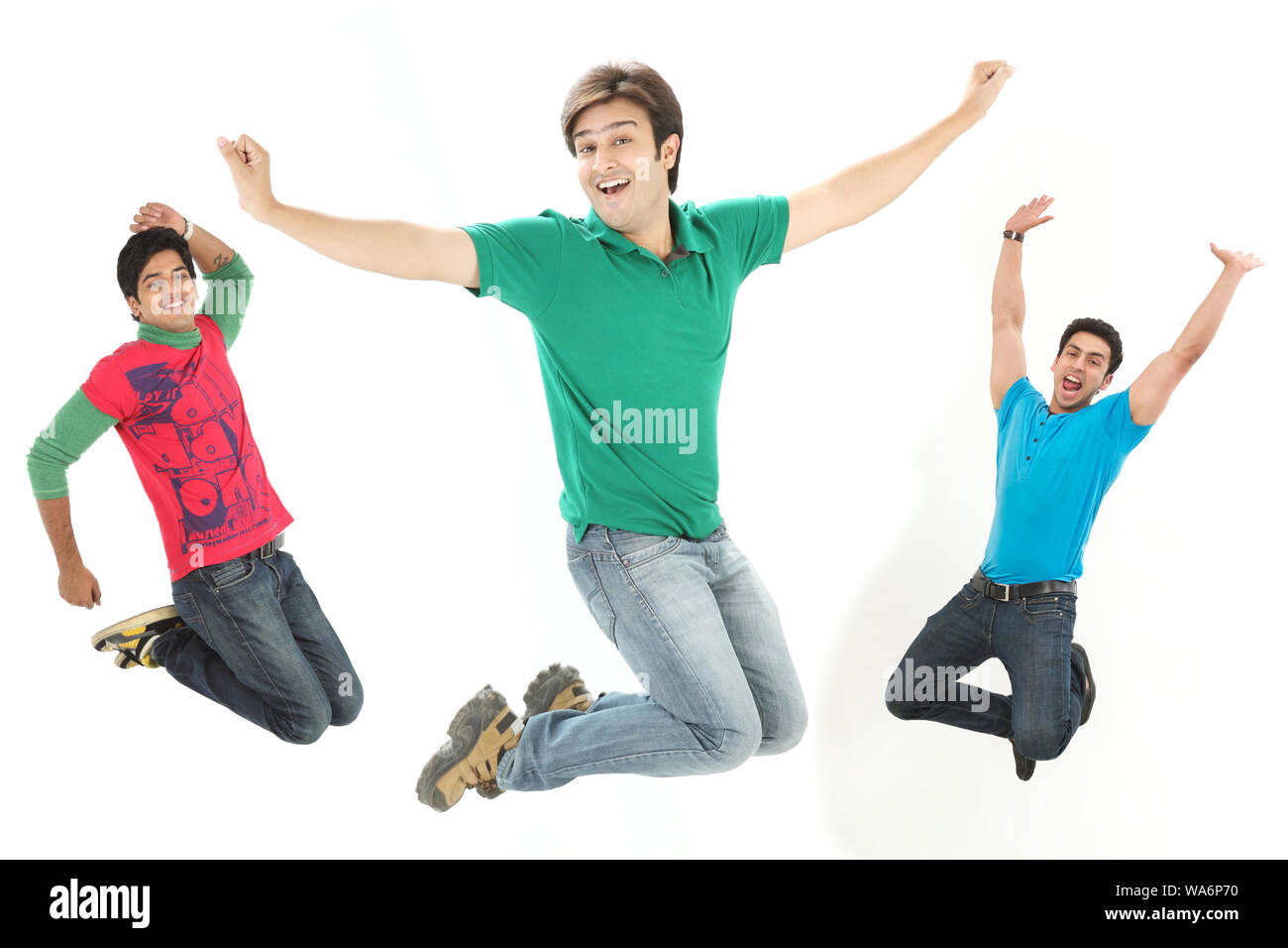 Giovani uomini che saltano a mezz'aria e sorridono Foto Stock