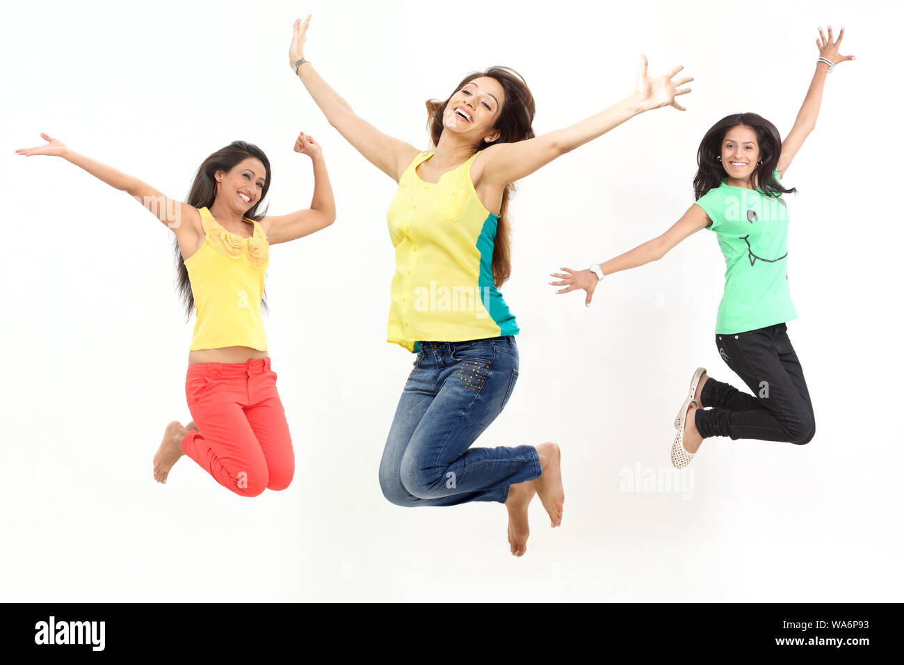 Le giovani donne saltano a mezz'aria e sorridono Foto Stock