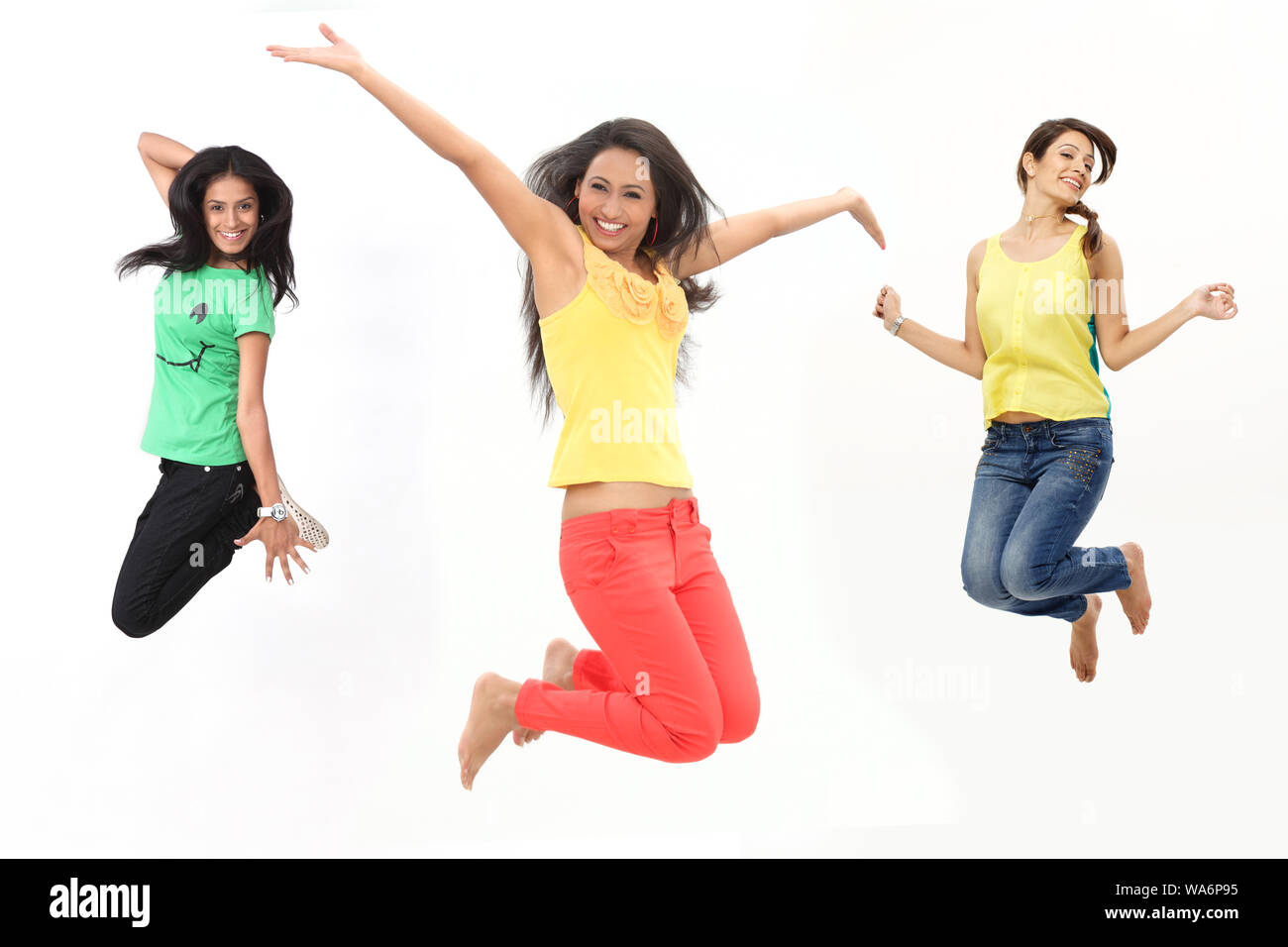 Le giovani donne saltano a mezz'aria e sorridono Foto Stock
