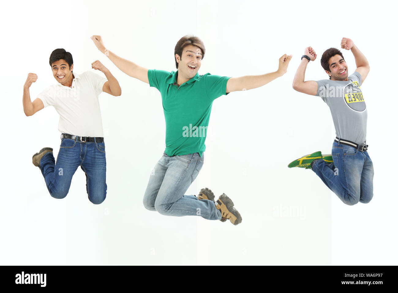 Giovani uomini che saltano a mezz'aria e sorridono Foto Stock