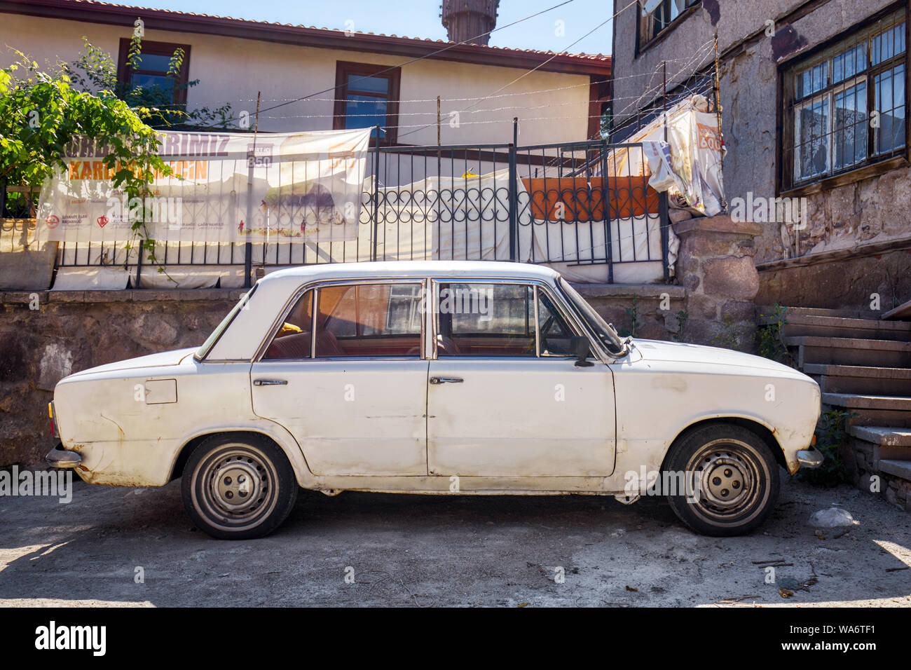 Vintage rottami Fiat 124 auto parcheggiate davanti a un shanty house nel ghetto di quartiere Hamamonu, Ankara, Turchia. Foto Stock