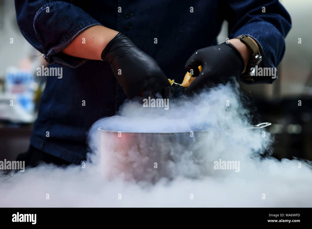 Azoto liquido in una padella. La cottura. Il vapore. Cuocere. Contro lo sfondo. Tutto ciò che accade in cucina. Foto Stock