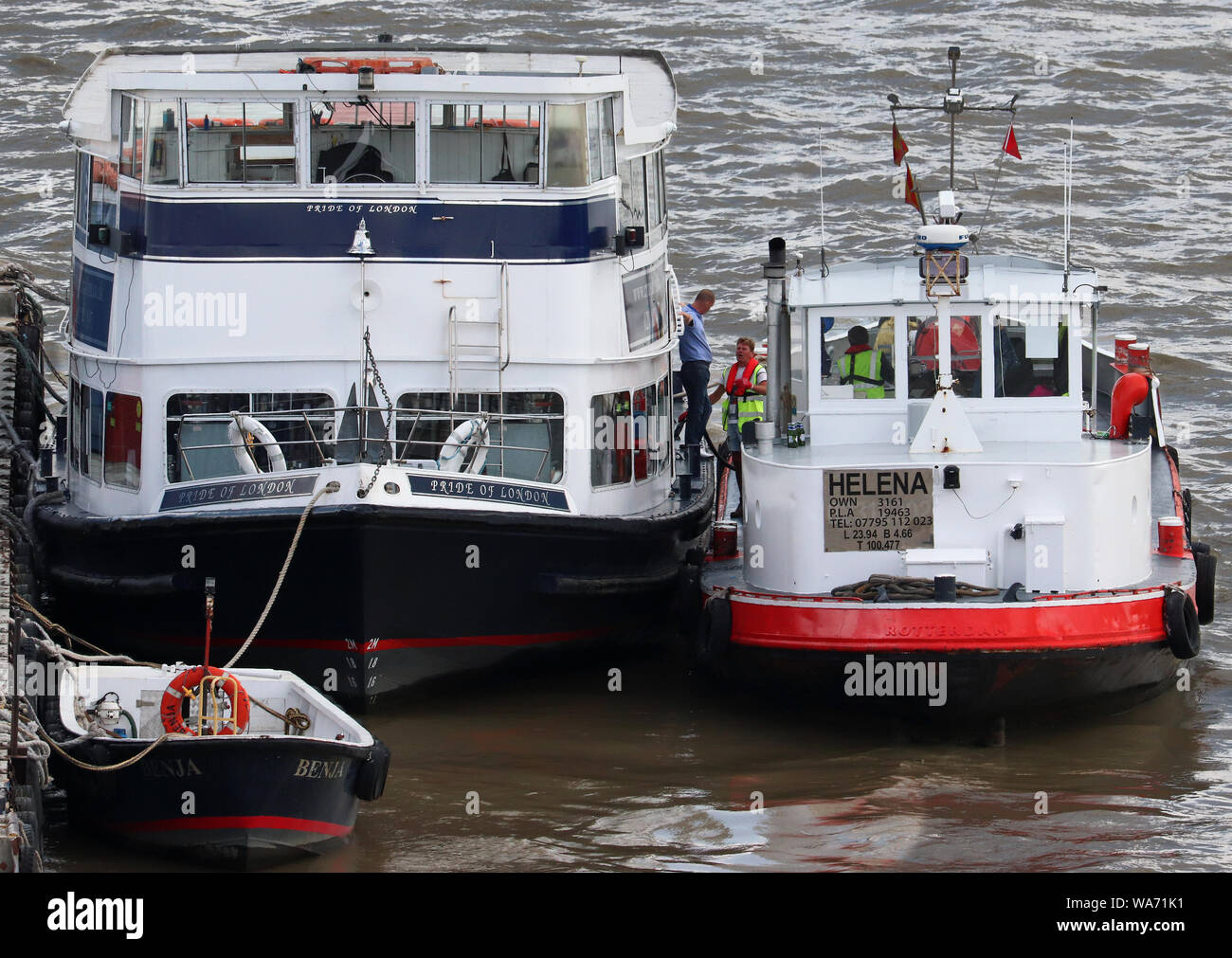 Due barche legata a un pontone nel fiume Thames, London Foto Stock