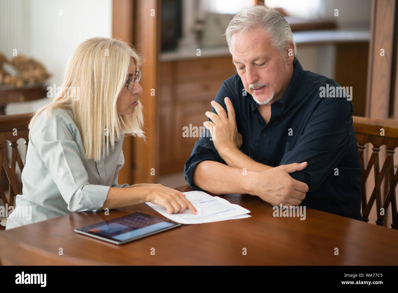 Coppia senior calcolare le loro spese di soggiorno insieme Foto Stock