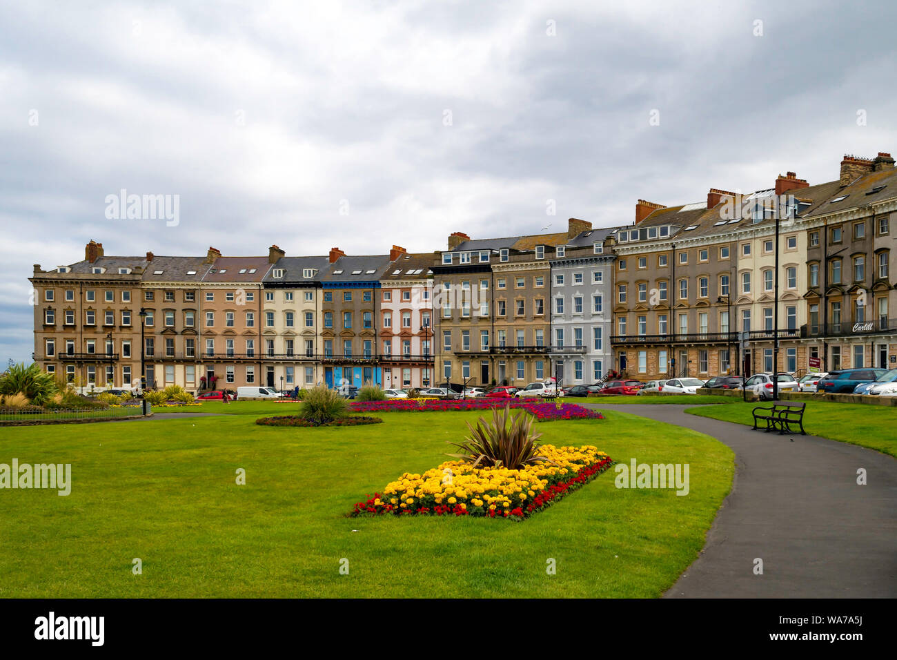 Royal Crescent una terrazza curvo del XIX secolo a sei piani a case di città sulla West Cliff Whitby affacciata su una formale Flower Garden Foto Stock