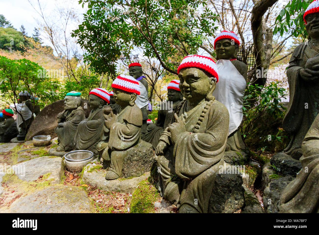 Giappone, Miyajima. Daisho-nel tempio, Rakan piccole statue di monaci buddisti, discepoli di Shaka, rivestimento gradino di pietra percorso. Close up. Foto Stock