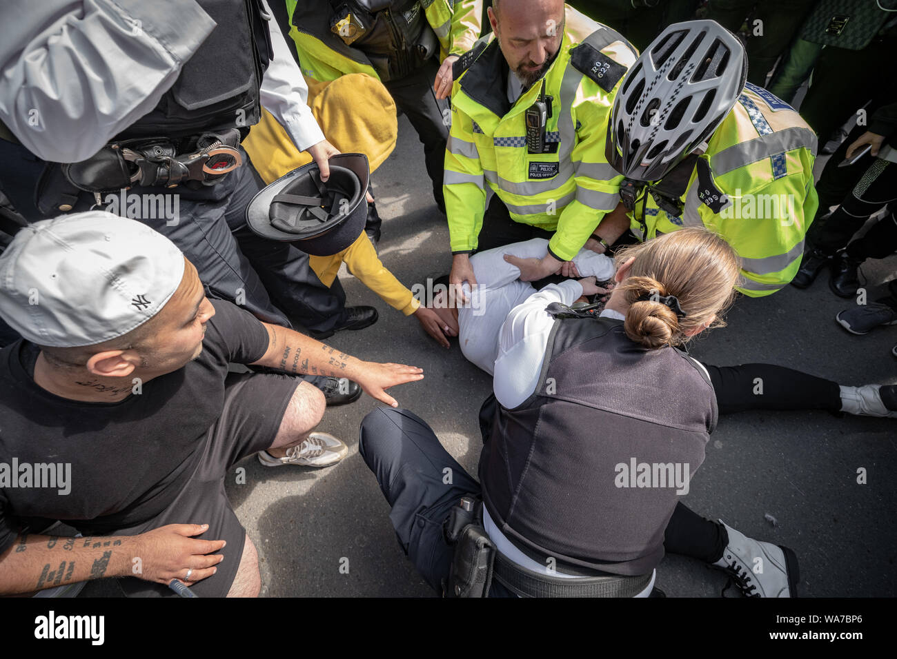 Londra, Regno Unito. Il 18 agosto, 2019. La polizia arresta una donna a Speakers' Corner in Hyde Park dopo ella divenne aggressiva e attaccato un funzionario di polizia che ha chiesto di lasciare il parco a causa di precedenti dispute arrabbiato e altercations fisico. Credito: Guy Corbishley/Alamy Live News Foto Stock